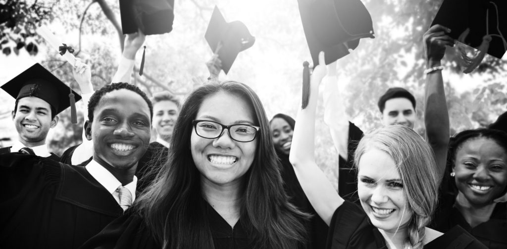 This is a picture of a group of diverse students celebrating their graduation. It is cropped